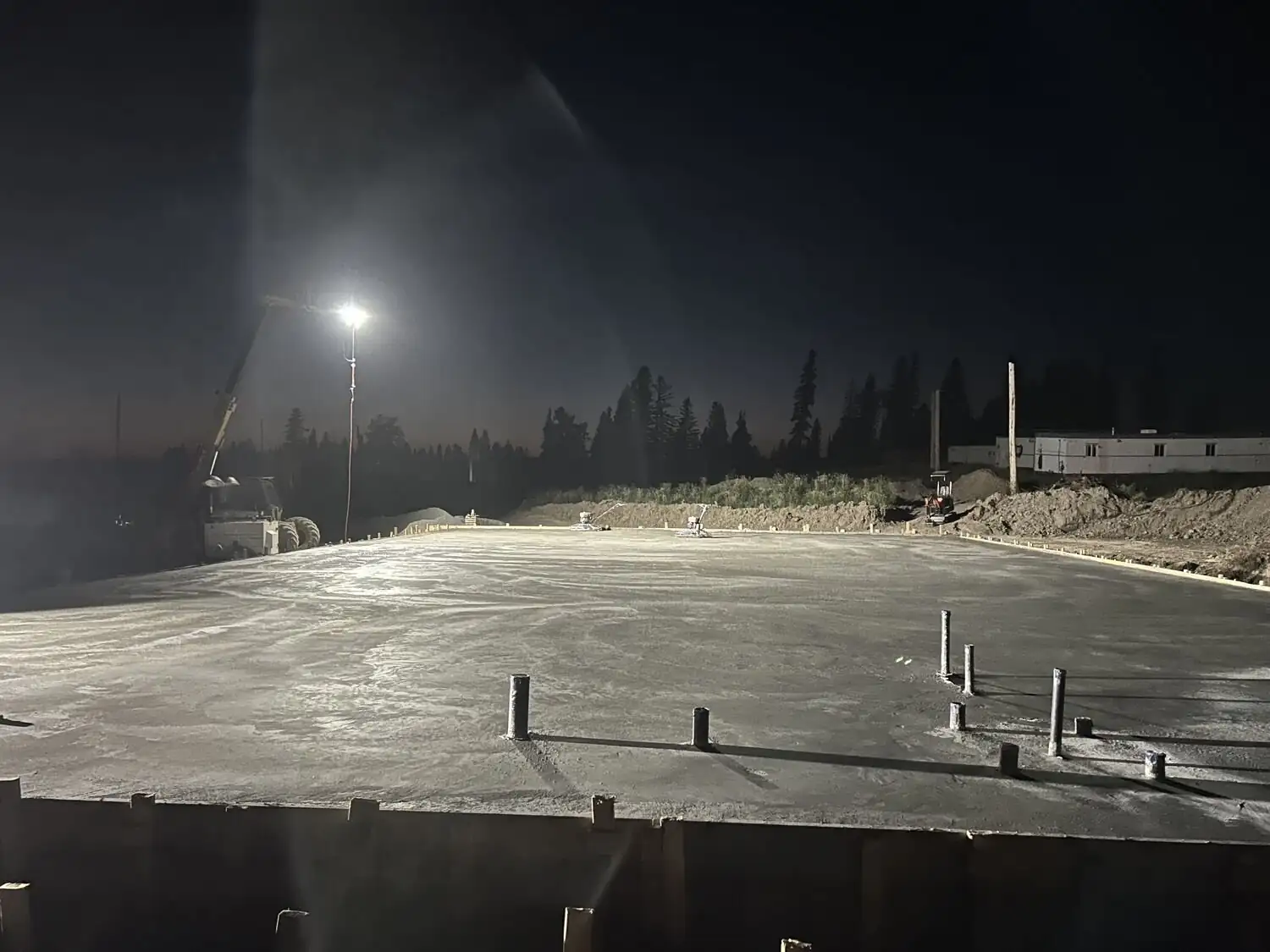 Concrete pour on a northern site at night under work lights.